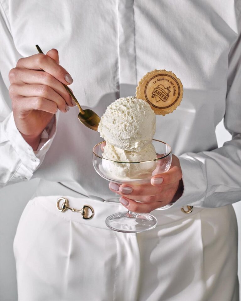 Person holding a glass with dessert