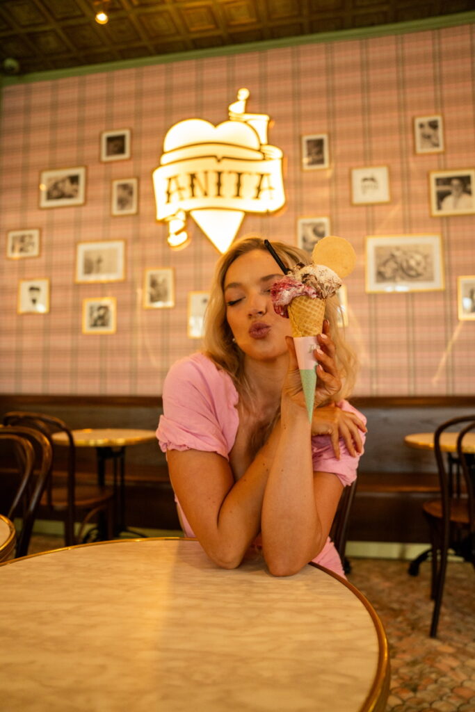 Blond woman holding cupcake at table