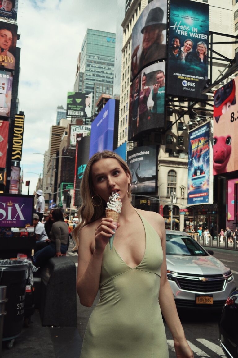 Woman in green dress enjoying ice cream in the city