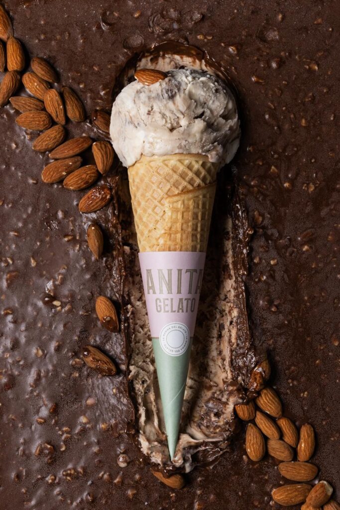 there is a cone of ice cream on a table with almonds
