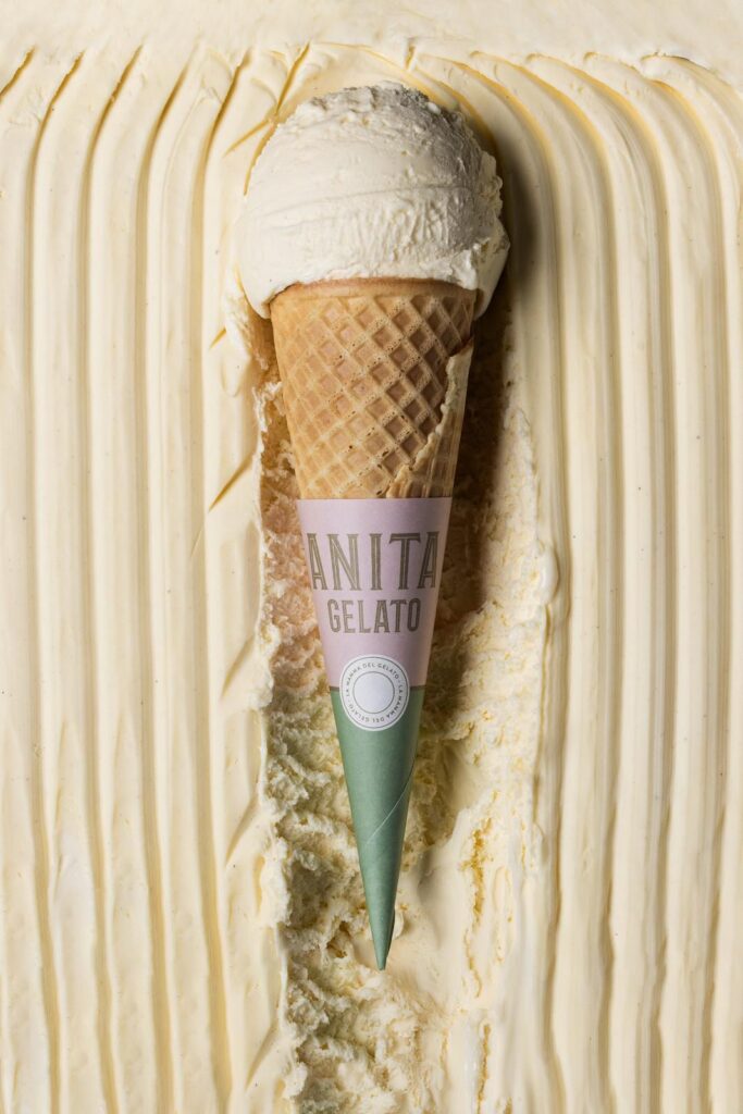 there is a cone of ice cream on top of a cake