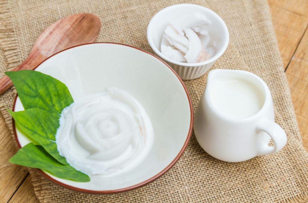 there is a bowl of yogurt and a cup of milk on a table