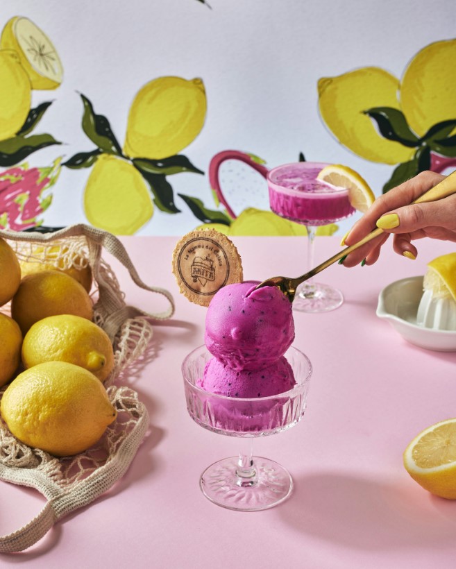 someone is scooping a scoop of ice cream into a bowl of lemons