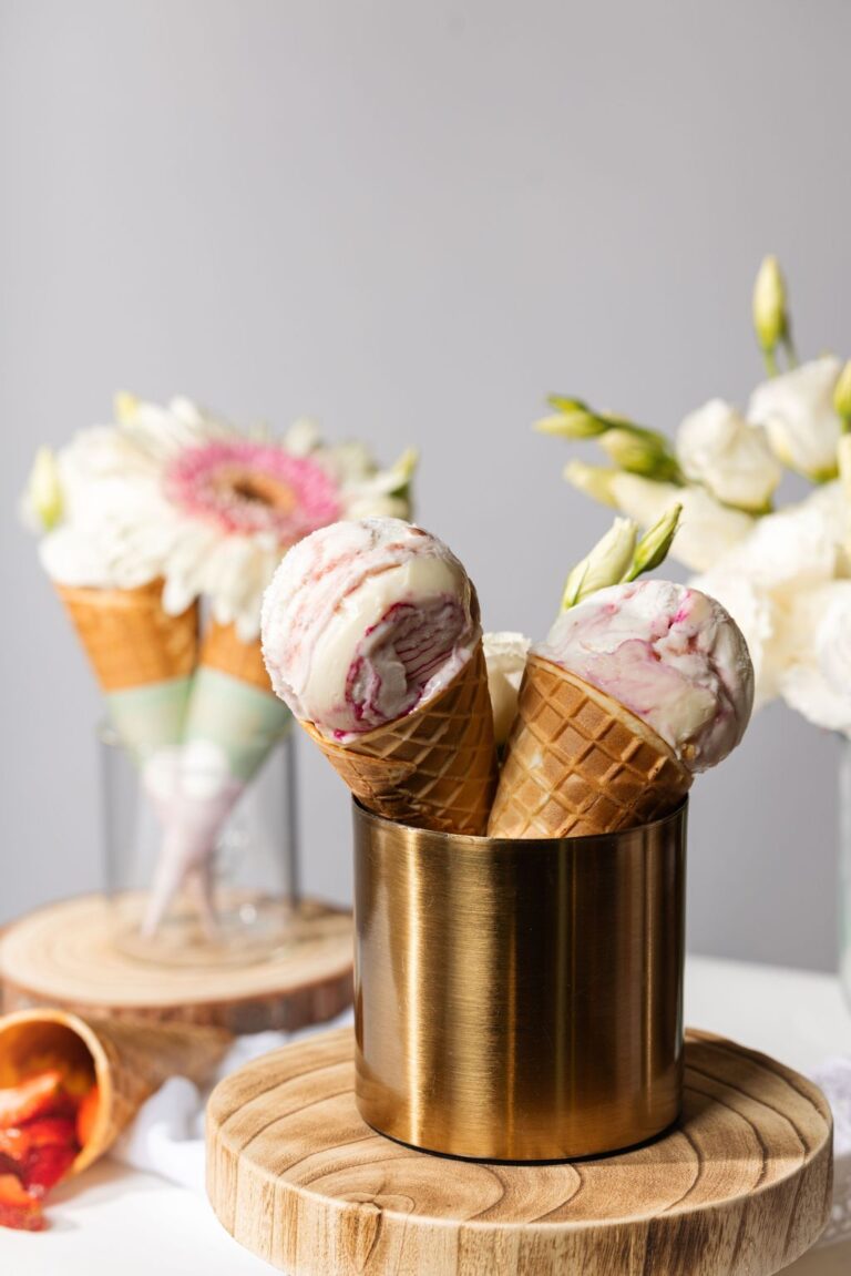 there are three ice cream cones in a gold cup on a table