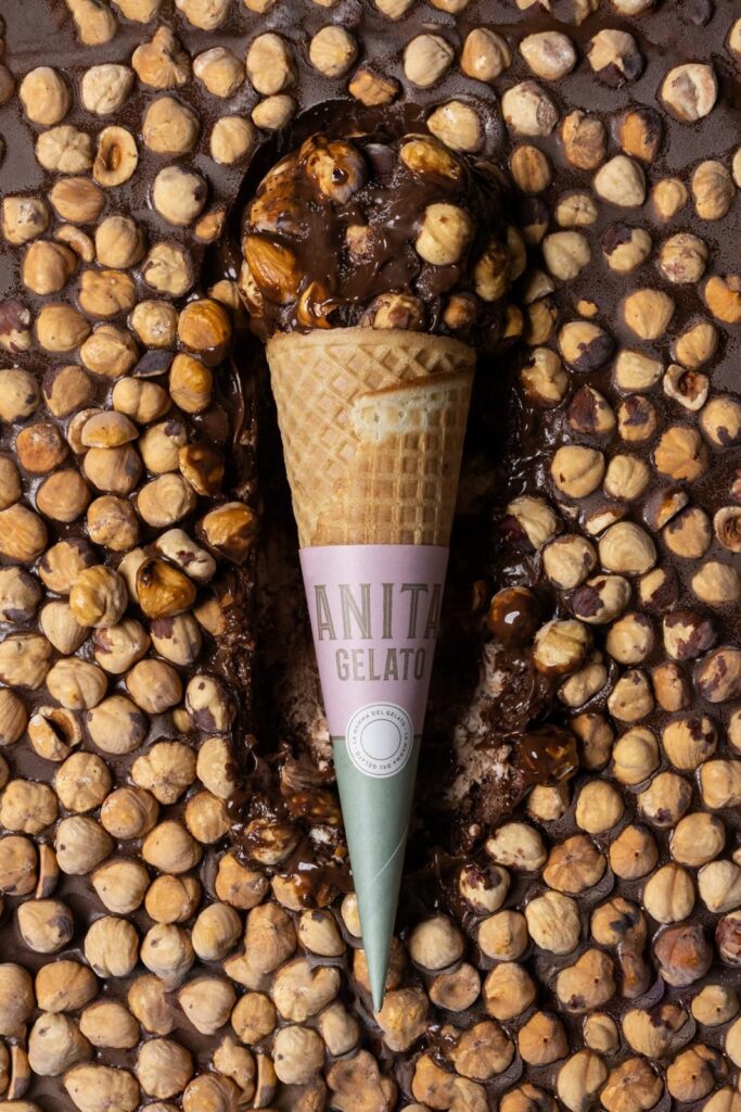 there is a cone of ice cream with nuts on top