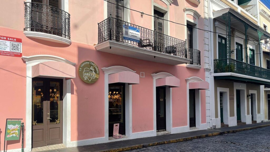 there is a pink building with a sign on the front of it