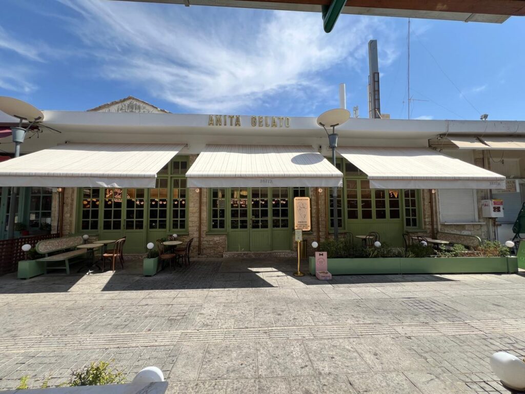 there is a large building with a white awning and a green bench