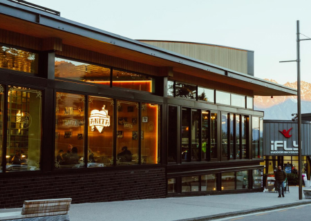 pedestrians walk past a restaurant with a sign that says the beer
