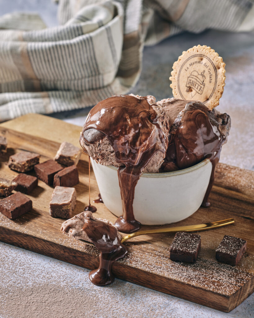there is a bowl of ice cream with chocolate sauce and cookies