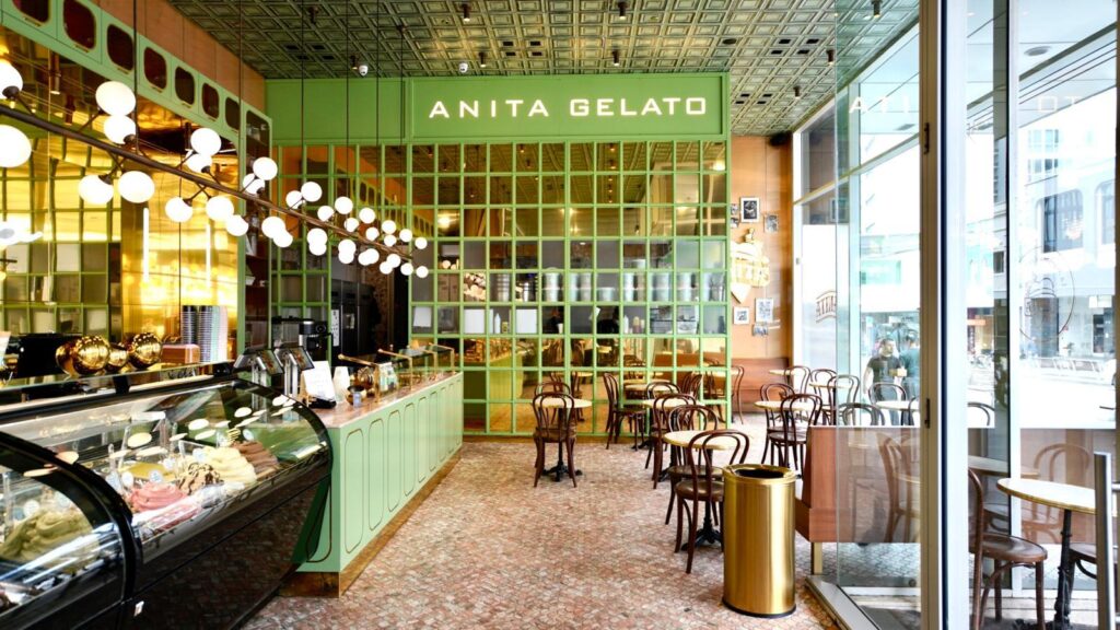 there is a large green and white restaurant with a lot of tables