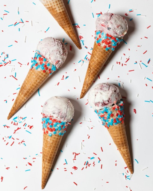 three cones of ice cream with sprinkles on a white surface