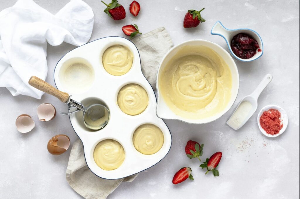 arafies in a pan with a spatula and a bowl of batter