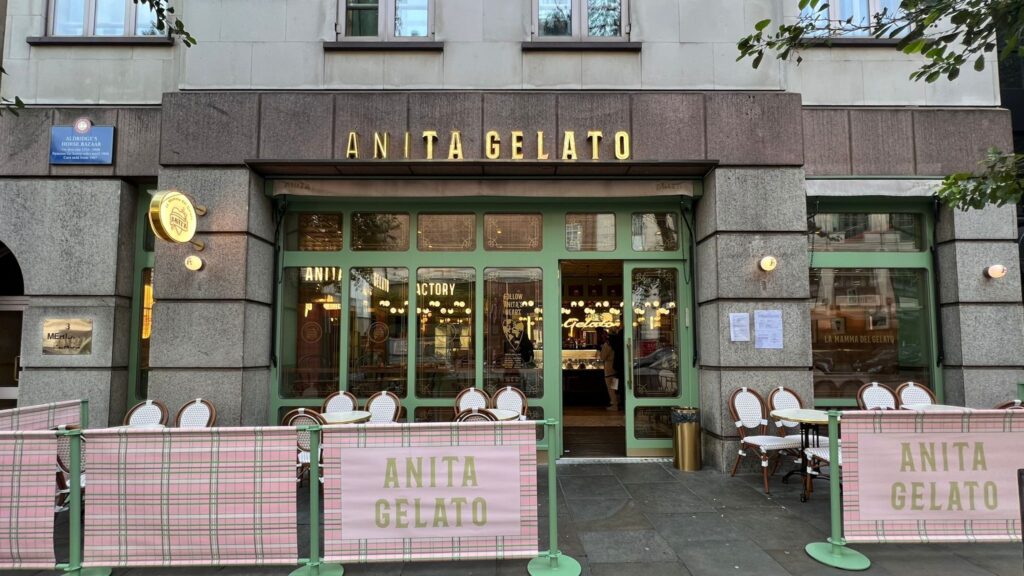 there is a restaurant with a pink tartan and a green gate