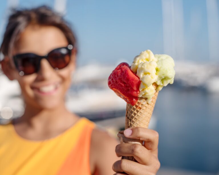 woman holding up a cone of ice cream with a variety of toppings