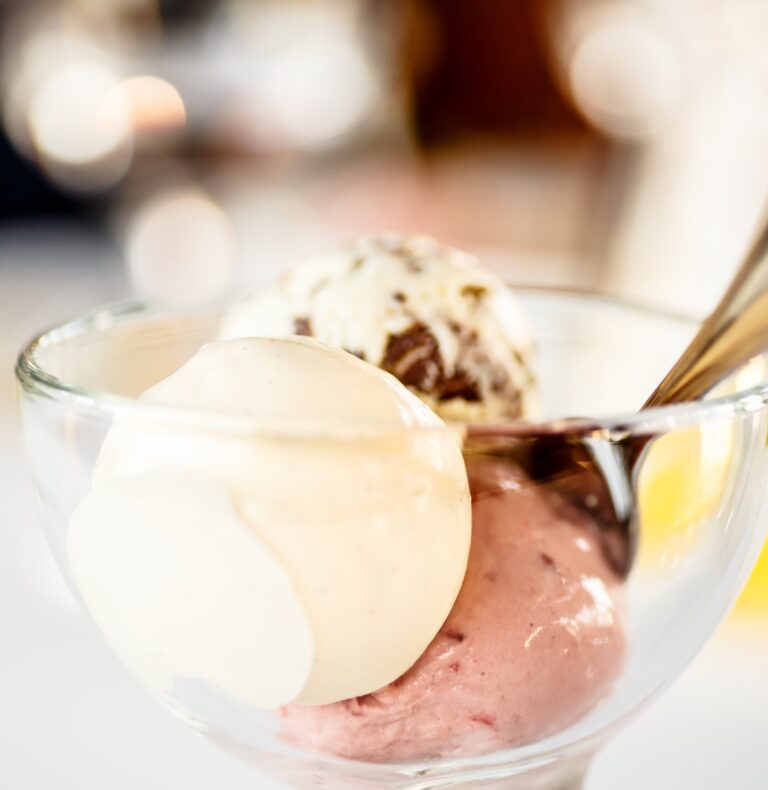 there is a glass bowl with ice cream and a spoon