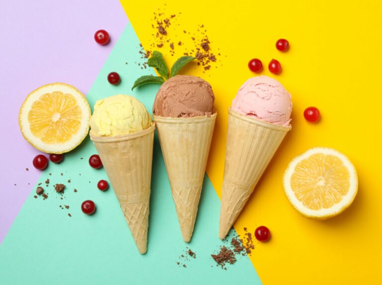 three ice cream cones with different flavors of ice cream and fruit