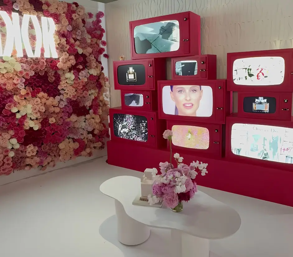 there is a table with a vase of flowers and a wall with pictures