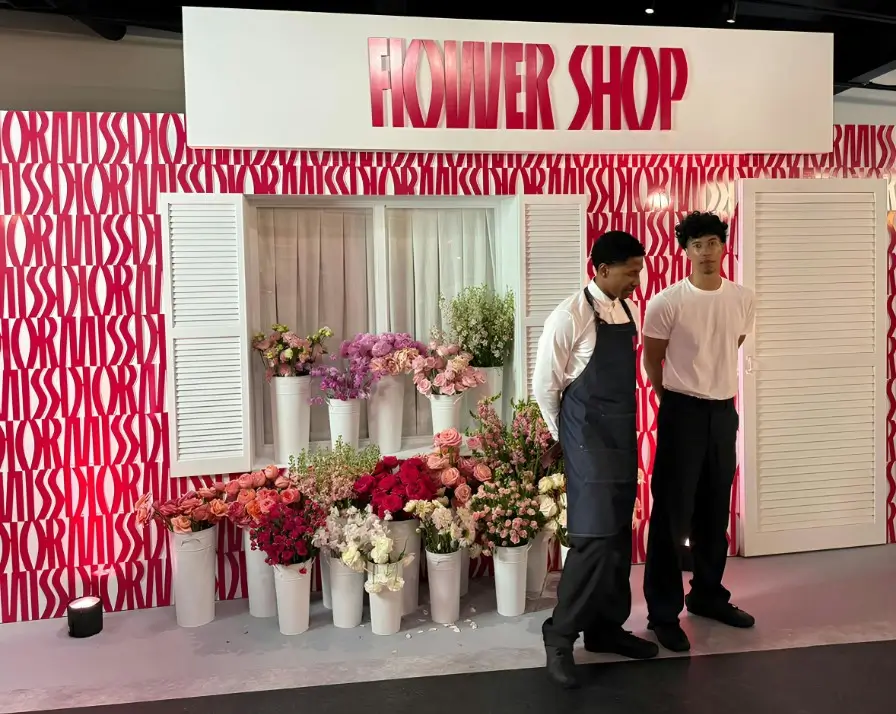 there are two men standing in front of a flower shop