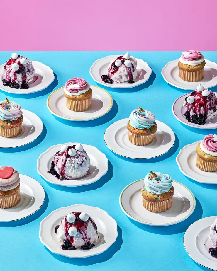 a close up of a table with a number of cupcakes on plates