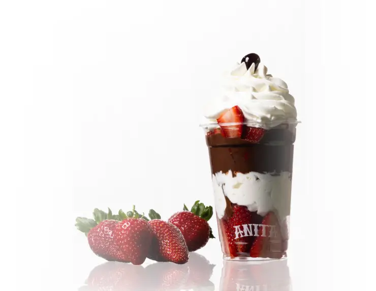 there is a cup of ice cream with strawberries and a strawberries