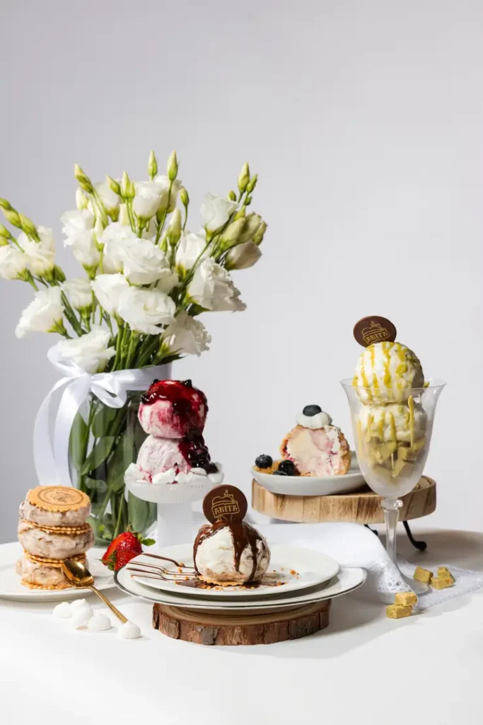 there is a vase of flowers and a plate of desserts